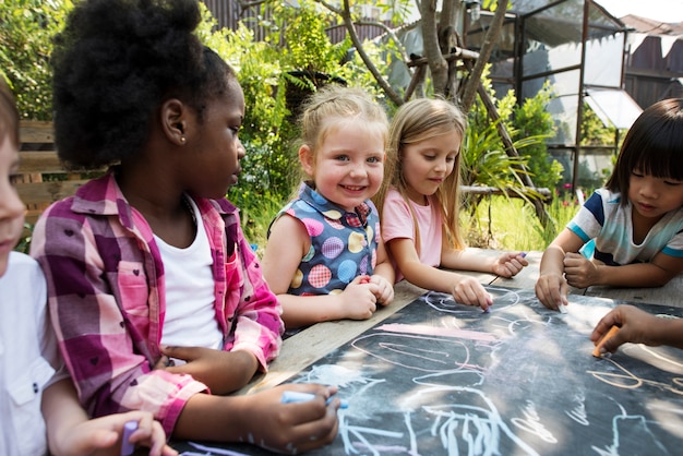 Gruppo di diversi bambini che attingono insieme lavagna