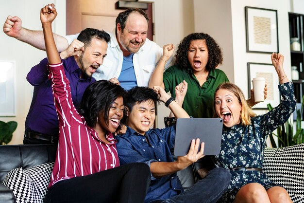 Gruppo di diversi uomini d'affari che guardano insieme un contenuto su un tablet digitale