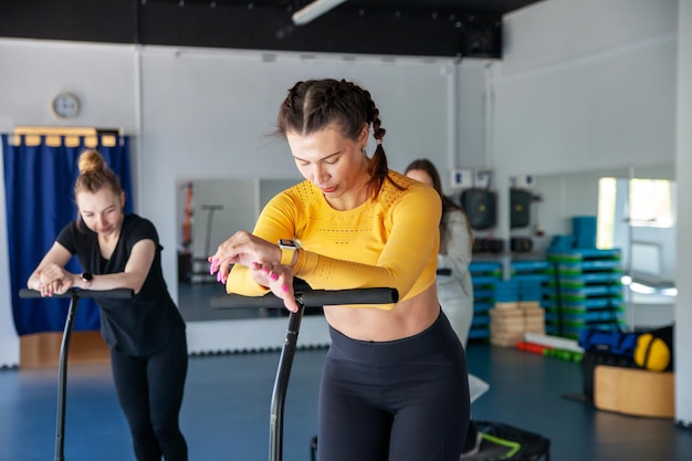 Gruppo di donne felici che si riscaldano prima dell'allenamento in palestra saltando sul trampolino