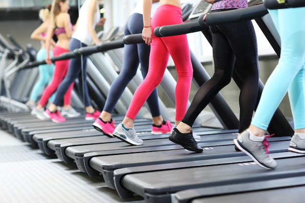 Gruppo di donne in forma che si allenano sul tapis roulant in palestra