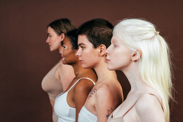 gruppo di donne multietniche con diversi tipi di pelle che posano insieme in studio
