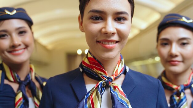 Gruppo di equipaggio di cabina o hostess di volo in aereo. Trasporto aereo e concetto di turismo.