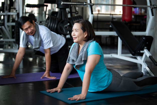 Gruppo di esercizio d'allungamento senior asiatico dell'amico alla palestra di yoga. stile di vita sano degli anziani.