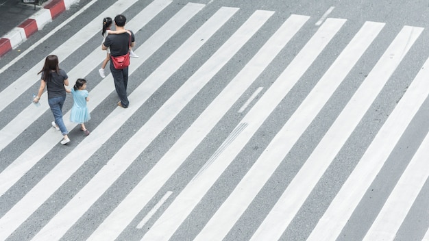 gruppo di famiglia con bambino a piedi sulla strada pedonale incrocio in città