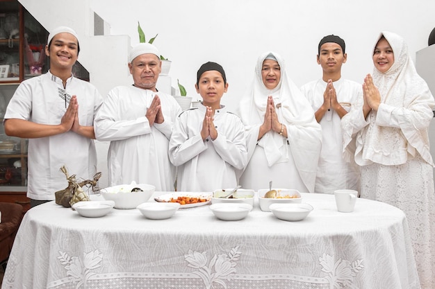 Gruppo di felice famiglia musulmana che gesturing le mani si scusa e dà il benvenuto per l'Eid Mubarak