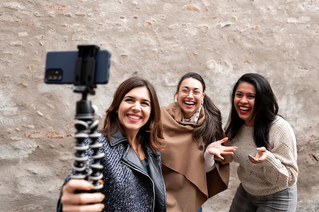 Gruppo di femmine felici multirazziali guardando smartphone. Donne che ridono e sorridono mentre fanno un selfie o fanno una videochiamata.