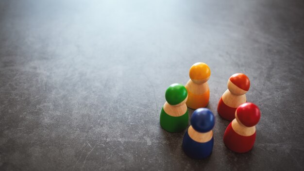 Gruppo di figurine in legno in diversi colori in piedi in cerchio per i concetti di diversità, uguaglianza e affari