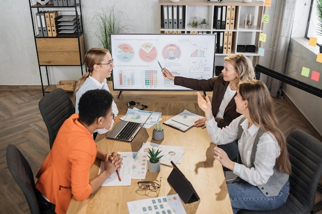 Gruppo di finanziere donne competenti che hanno riunioni di lavoro in ufficio