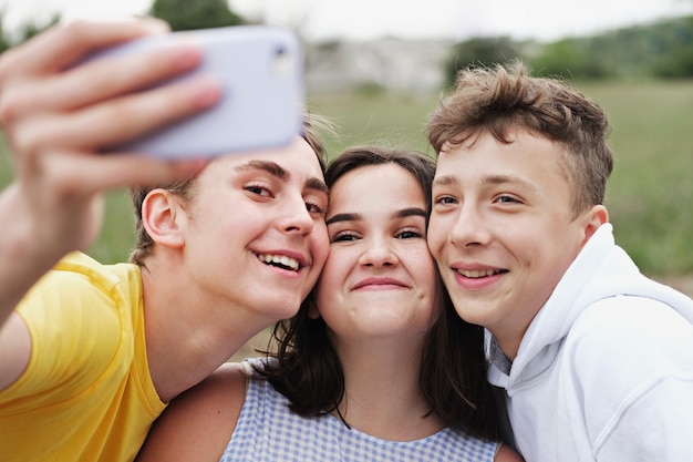 Gruppo di giovani amici adolescenti che prendono un selfie
