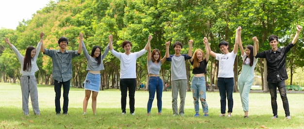 Gruppo di giovani amici asiatici uscire e rilassarsi insieme al parco all'aperto