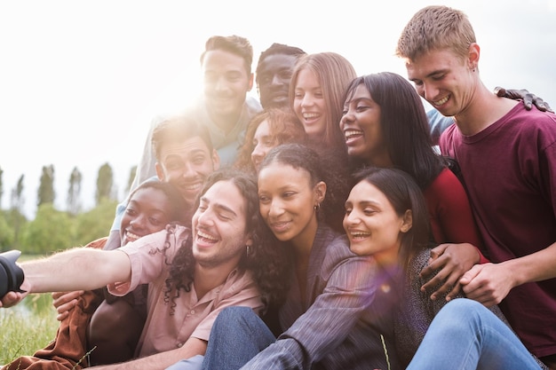 Gruppo di giovani amici di culture diverse che si fanno un selfie all'aperto dopo un pomeriggio divertente