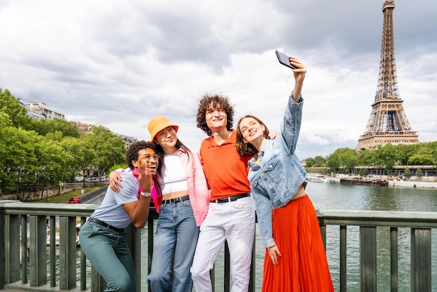 Gruppo di giovani amici felici che visitano Parigi e la Torre Eiffel