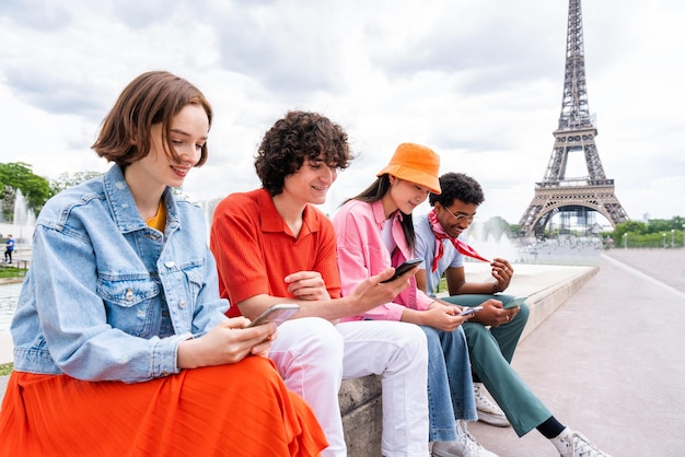 Gruppo di giovani amici felici che visitano Parigi e la Torre Eiffel