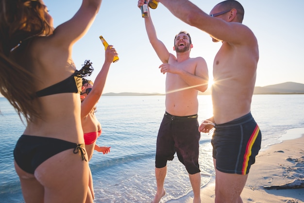 gruppo di giovani amici multietnici spiaggia estiva