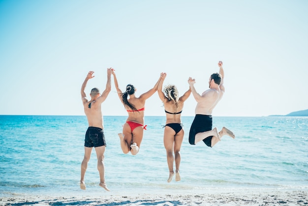 gruppo di giovani amici multietnici spiaggia estiva