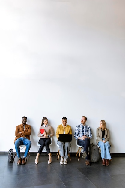 Gruppo di giovani annoiati in attesa del colloquio di lavoro