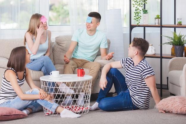 Gruppo di giovani che giocano giochi al chiuso. Gioventù attiva. Felice gente sorridente che si diverte. Studenti durante le vacanze.