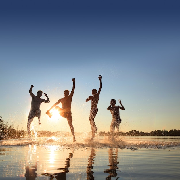 Gruppo di giovani che giocano sulla spiaggia sabbiosa in una giornata estiva.