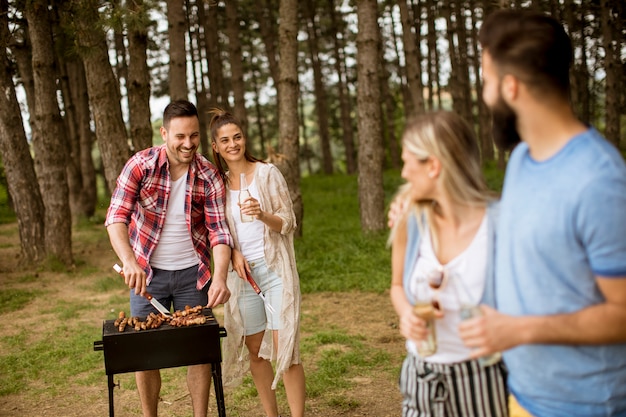 Gruppo di giovani che godono barbecue party nella natura