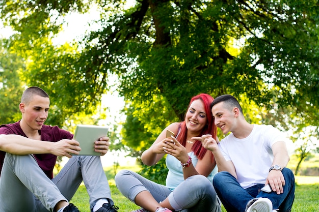 Gruppo di giovani che utilizzano la tecnologia nel parco