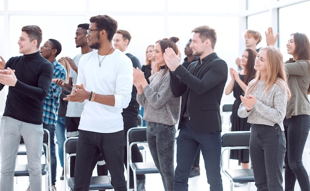 Gruppo di giovani diversi che applaudono insieme affari e istruzione