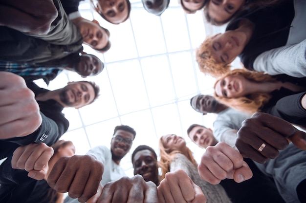 Gruppo di giovani diversi che uniscono le mani in un anello