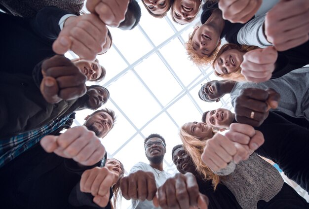 Gruppo di giovani diversi che uniscono le mani in un anello