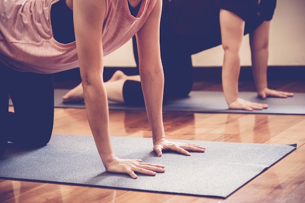 Gruppo di giovani donne asiatiche in buona salute che praticano lezione di yoga con l'istruttore in studio domestico