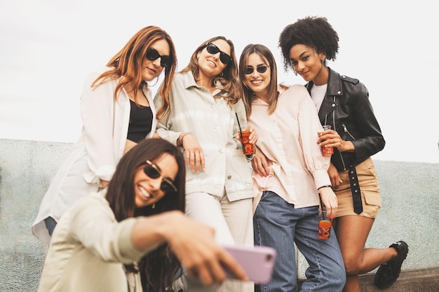 Gruppo di giovani donne che prendono selfie