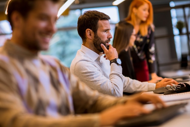 Gruppo di giovani imprenditori stanno lavorando insieme al desktop computer