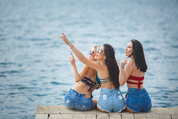 Gruppo di giovani ragazze allegre che hanno divertimento in spiaggia