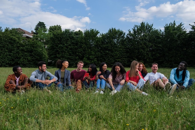 Gruppo di giovani seduti nel parco che si divertono insieme