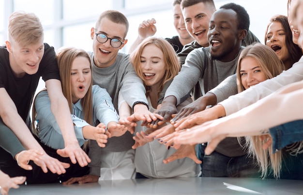 Gruppo di giovani sorridenti che uniscono le loro mani