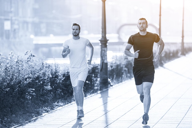 gruppo di giovani sportivi che fanno jogging al mattino soleggiato in città