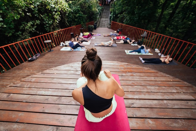 Gruppo di giovani sportivi che praticano la lezione di yoga con istruttore