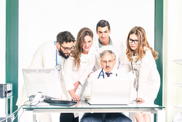 Gruppo di giovani studenti di medicina con medico senior presso la clinica sanitaria