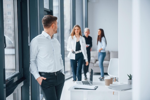 Gruppo di giovani team di successo che lavorano e comunicano insieme al chiuso in ufficio