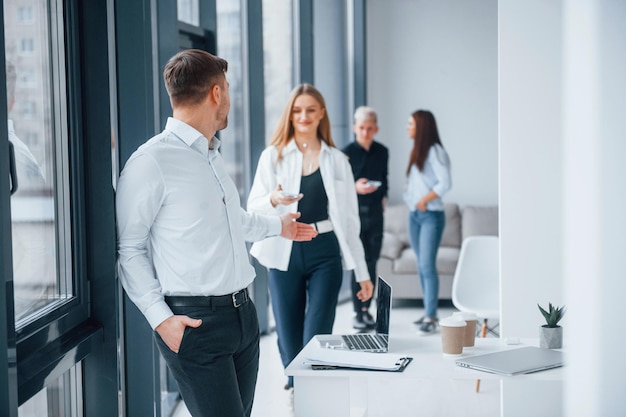 Gruppo di giovani team di successo che lavorano e comunicano insieme al chiuso in ufficio