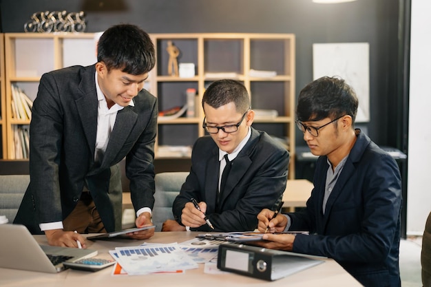 Gruppo di giovani uomini d'affari che discutono del piano aziendale all'avvio moderno in attività creative che discutono del lavoro moderno edificio per ufficixA