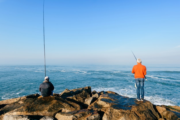 Gruppo di irriconoscibili uomini adulti che pescano