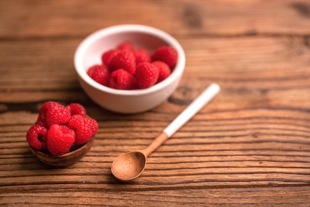 Gruppo di lamponi in una ciotola bianca. Uno stile di vita sano. Frutta fresca.