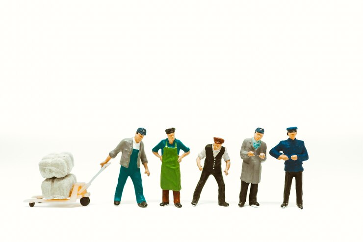 Gruppo di lavoro in miniatura della gente isolato su fondo bianco