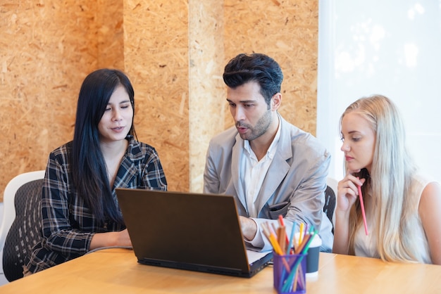 Gruppo di lavoro presente di affari. Colleghi di lavoro che parlano di piano o nuovo progetto. avere l'uso del laptop durante una riunione e regali.