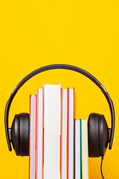 Gruppo di libri con gli auricolari. Concetto di audiolibri