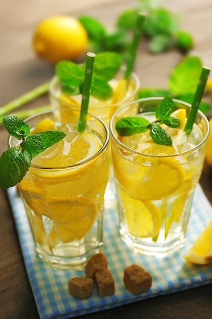 Gruppo di limonate con limoni e menta su sfondo tavolo in legno