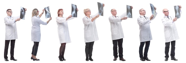 Gruppo di medici che tengono raggi x isolati su bianco