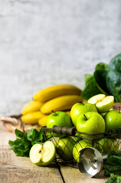 Gruppo di mele verdi sane, spinaci, banane e menta sono gli ingredienti per un frullato. Detox, dieta, concetto di cibo sano e vegetariano. Spazio libero per il testo. Copia spazio.