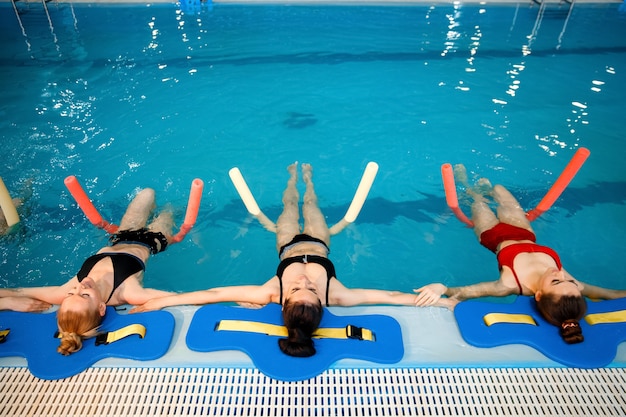 Gruppo di nuotatrici, allenamento di aerobica in acqua a bordo piscina