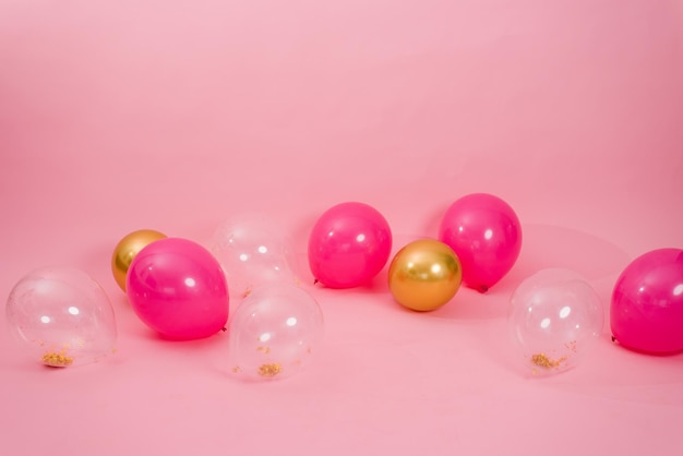 Gruppo di palloncini rosa trasparenti e dorati multicolori sdraiati sul pavimento della casa per il concetto di vacanza di compleanno del giorno di San Valentino