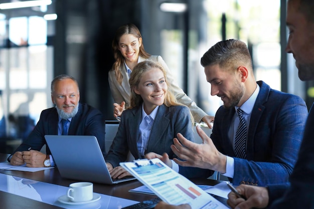 Gruppo di partner commerciali che discutono di idee e di pianificazione del lavoro in ufficio